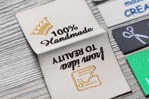 Flexinera kangasetiketti keskitaitteella ja tekstillä '100% Handmade' - Nimikenumero 3002